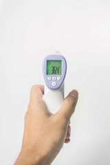 hand holding digital infrared thermometer isolated on white background. with copy space
