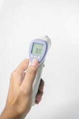 hand holding digital infrared thermometer isolated on white background. with copy space