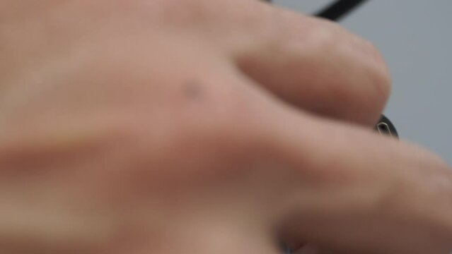 Close up view black lock screw on camera stand. Technician hand turn to loosen and tighten the grip