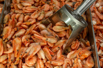 A lot of frozen boiled shrimp on the counter in a supermarket. Healthy eating, vitamins and diet. Close-up Top view. Background.
