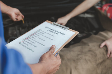 The mechanic is repairing the engine, A car repair worker is inspecting a car, A car mechanic is looking at what is the problem with the engine in the garage.