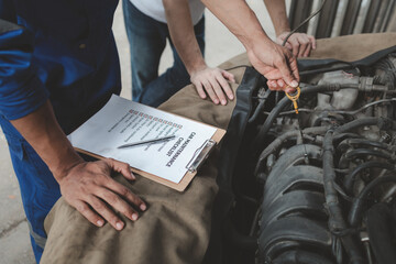 The mechanic is repairing the engine, A car repair worker is inspecting a car, A car mechanic is...