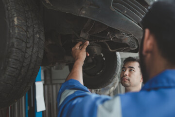 The mechanic is repairing the engine, A car repair worker is inspecting a car, A car mechanic is...