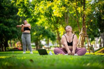Naklejka na ściany i meble An obese woman who turns to exercise to take care of her health and lose weight on lawn in a fun way