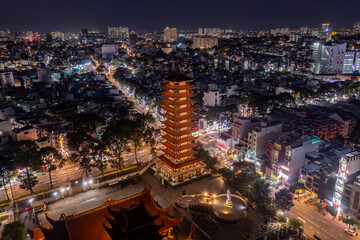 Buddhist pagoda and aerial night view of  Ho Chi Minh City,  Vietnam.