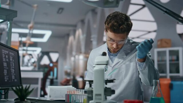 Young microbiologist experimenting medicines in clinic laboratory close up. 