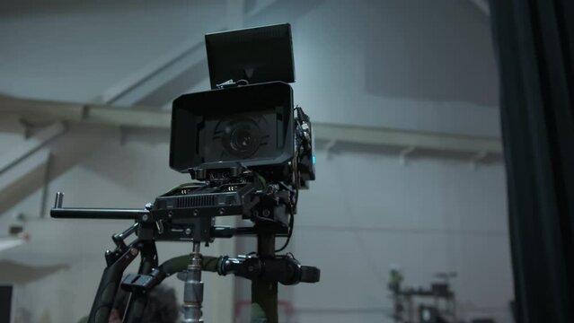 Professional digital cinema camera with set of light hanging in studio background. Close up footage