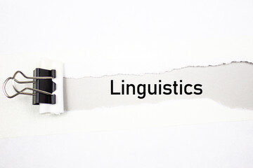 LINGUISTICS text, acronym on torn paper. Linguistics inscription, scientific concept.