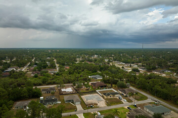 Dark stormy clouds forming on gloomy sky before heavy rainfall over suburban town area