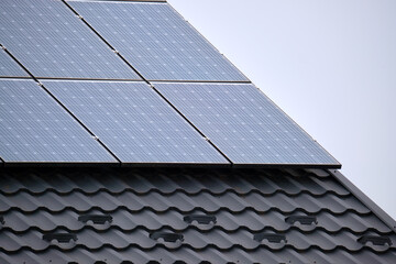 Private home roof covered with solar photovoltaic panels for generating of clean ecological electric energy in suburban rural town area. Concept of autonomous house