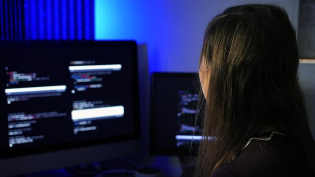 Female programmer programming artificial intelligence language models using code on multiple screens
