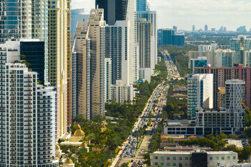 Obraz premium View from above of luxurious highrise hotels and condos on Atlantic ocean shore in Sunny Isles Beach city. Urban street with busy traffic. American tourism infrastructure in southern Florida