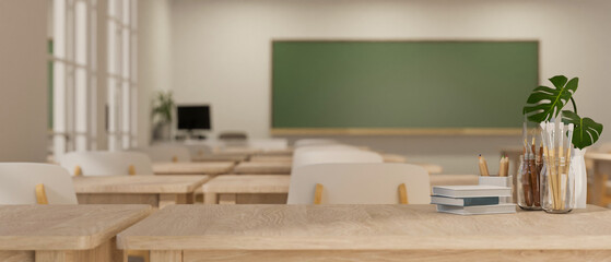 Close-up image of a copy space, books, and stationery on a wooden study table in a classroom.