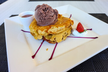 Pancake with chocolate ice cream and strawberry in a serving plate