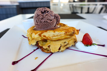 Pancake with chocolate ice cream and strawberry in a serving plate