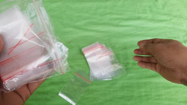 Opp bag.Transparent mini plastic bag held by a person, small plastic packaging using adhesive, product wrapping, 4k footage