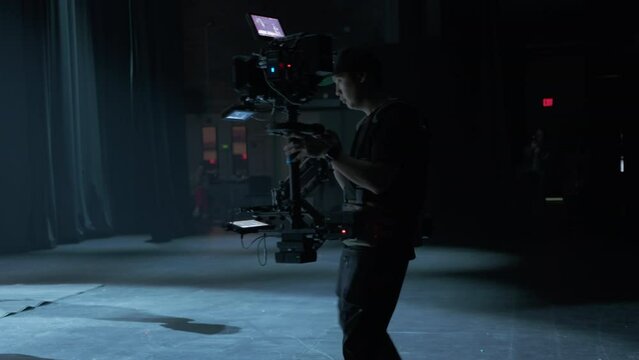 Professional digital cinema camera with set of steadicam in studio background. 