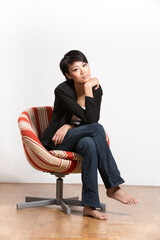 Pretty young Chinese girl sitting on chair