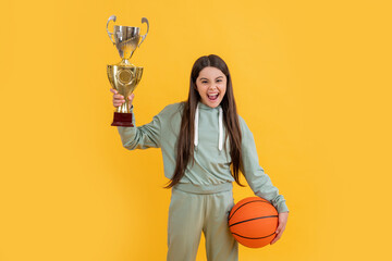 sport success. happy girl won prize. back to school. Celebrating success. winning the game. sport champion. teen girl with basketball ball and champion cup. happy basketball champion - obrazy, fototapety, plakaty