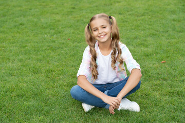 childhood lifestyle of teen. relax on summer lawn. girl relax peacefully on the grass. happy childhood of teen girl. summer relax in park. teen girl sitting outdoor. freedom and joy
