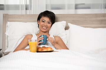 Obraz na płótnie Canvas Chinese Woman having breakfast in bed