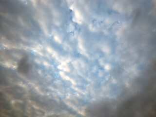 Blue sky with multitude small clouds texture pattern. A crowded background of tiny fluffy clouds for a design.