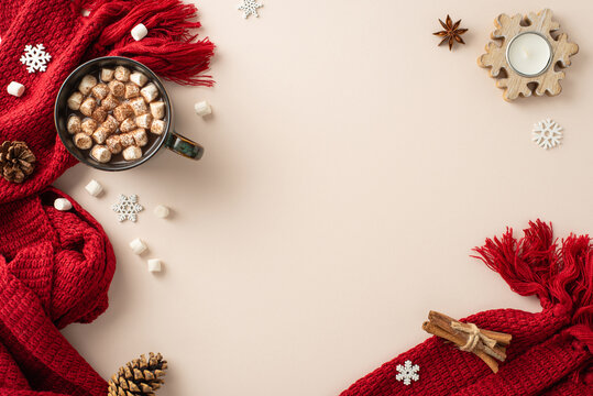 Warm winter aesthetics: Overhead view of a hot chocolate mug adorned with marshmallows, candle, spices, pine cones, snowflakes, and a red scarf on a beige surface, text-friendly space - Powered by Adobe