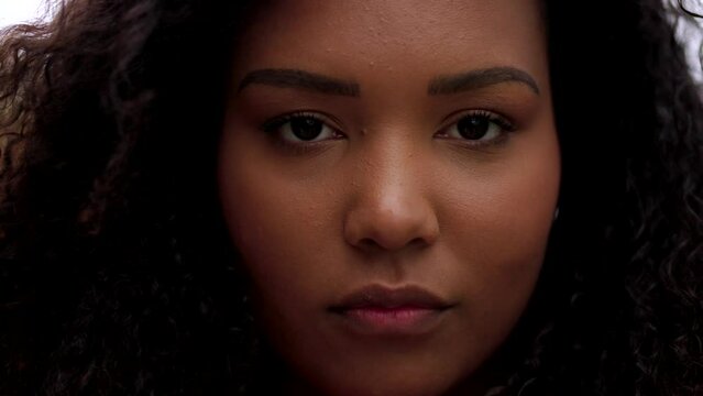 Closeup portrait of young black curvy woman. African American serious person looking at camera