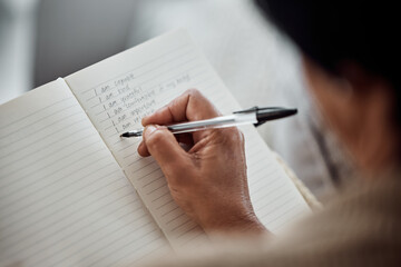 Hand, book and writing for affirmation with an old woman in her home for support or motivation....