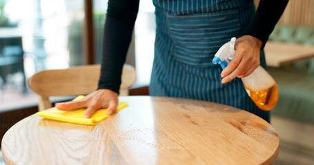 Waiter, hands and cleaning table in cafe for dust, bacteria and dirt with cloth, spray or...