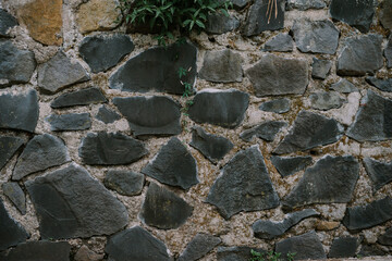 Several large stones are arranged and cemented for a building wall to make it stronger and stronger