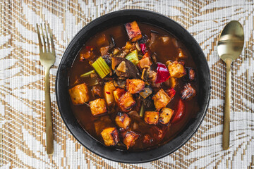 plant-based hot pot with tofu and aubergine and mixed vegetables in spicy broth