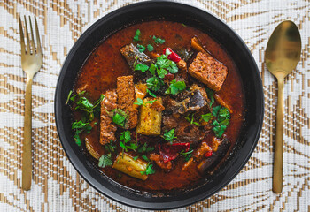 plant-based hot pot with tempeh and zucchini and mixed vegetables in spicy broth