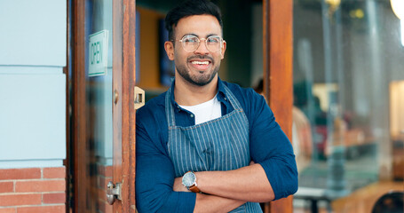 Waiter, man and portrait with arms crossed or happy for service, welcome or server in coffee shop. Barista, person and face with smile for hospitality, career or confidence at entrance of restaurant