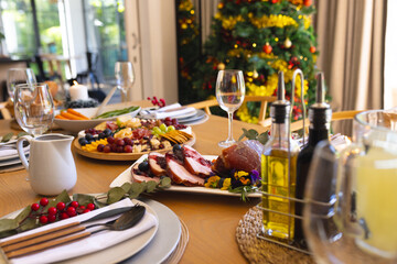 Table with delicious meal prepared for christmas dinner in sunny dining room