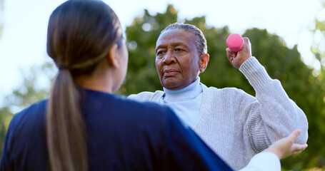 Dumbbell, exercise and a senior black woman with a nurse outdoor in a garden together for physiotherapy. Fitness, health or wellness with an elderly patient and medical nurse in the yard to workout