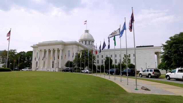 Alabama state capitol building in Montgomery, Alabama with gimbal video showing flags walking forward in slow motion.