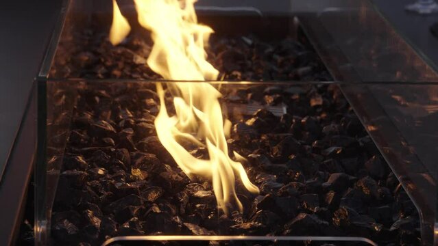 Close-up shot of black charcoal fire glowing incorporated into a table
