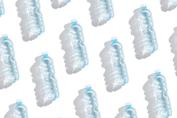 Pattern small plastic bottles with clean drinking water at sunlight, shadow on white background. Full closed bottle water half litre. Pollution, plastic garbage, non-biodegradable packaging waste