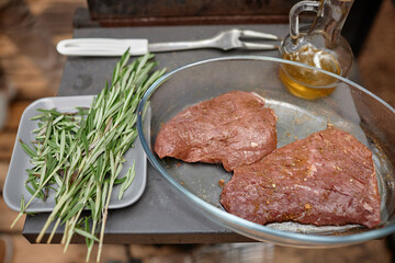 High angle view of marinated meat preparing for cooking on grill with herbs and oil