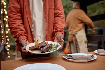 Foto op Canvas Close-up of African American man serving fried meat at picnic outdoors © AnnaStills
