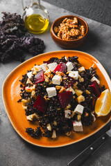 Salad of kale, roasted beets, walnuts and feta cheese on the table vertical photo