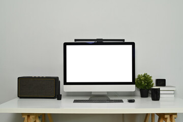 Modern workplace with bank screen of desktop computer on desk. White empty screen for graphic display montage