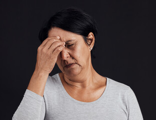 Frustrated senior woman, headache and anxiety in studio for depression, debt and confused on black...