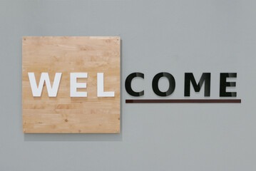 Welcome sign set on a wood background and grey cement