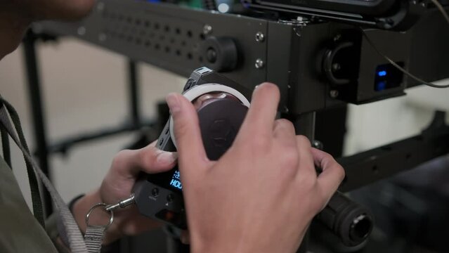 Focus puller hands at work, spins the focus wheel. Close up