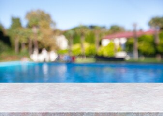 Empty blank table top on swimming pool background