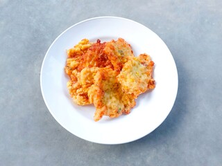 Perkedel jagung. Corn fritters on a plate on a gray background. Yummy Indonesian Sweetcorn Fritters. very popular in Indonesia. a snack that is often enjoyed as a snack or side dish.
