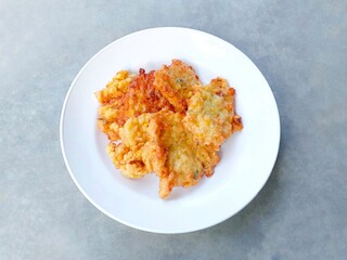 Perkedel jagung. Corn fritters on a plate on a gray background. Yummy Indonesian Sweetcorn Fritters. very popular in Indonesia. a snack that is often enjoyed as a snack or side dish.
