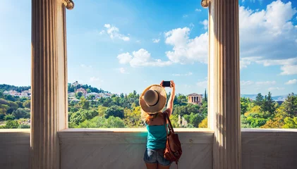 Tuinposter Athene Woman tourist looking at Temple of Hephaestus, Athens in Greece- Ancient Agora